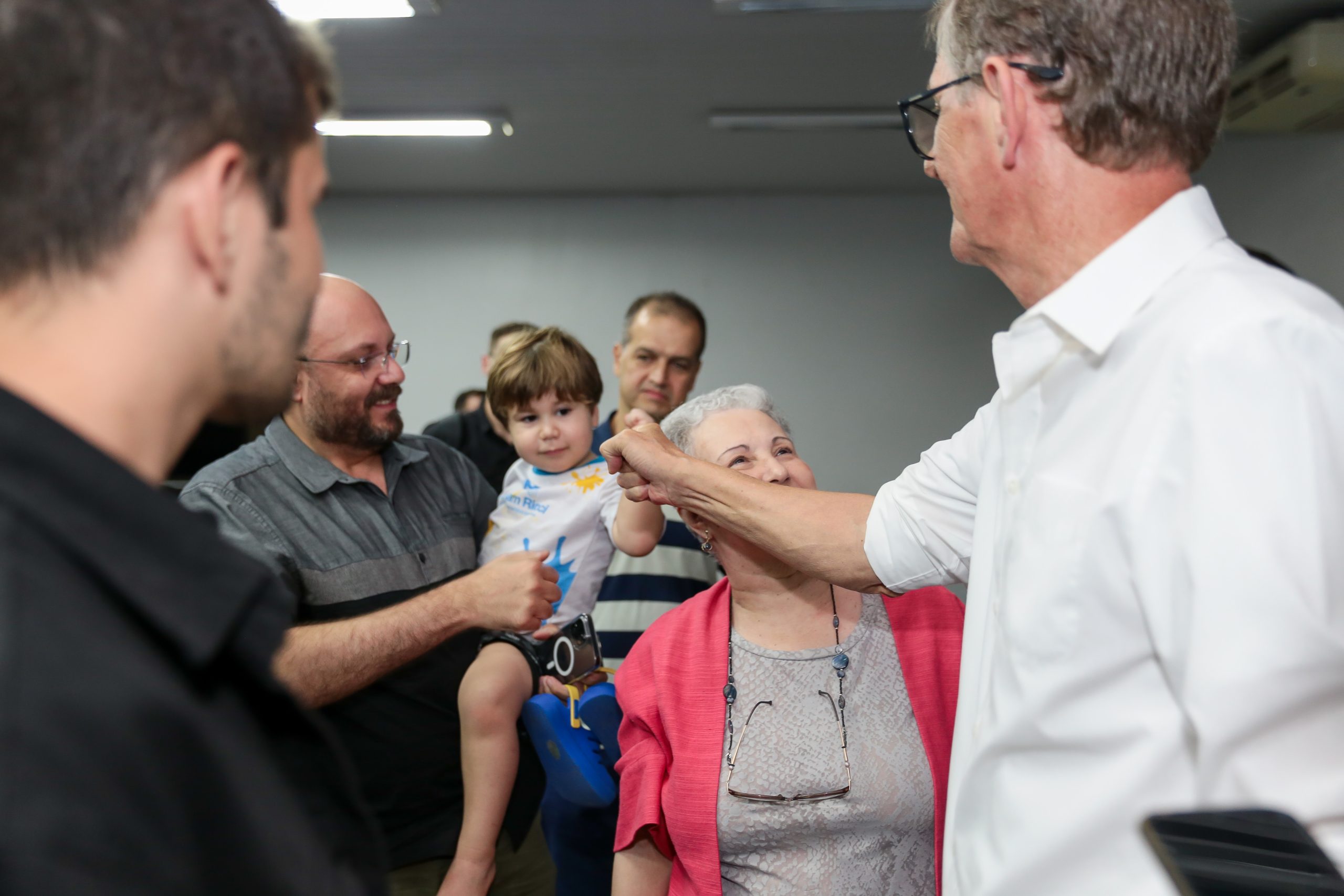 Emanuel Fernandes veste camisa branca e cumprimenta apoiadores durante palestra na ETEP Faculdades.