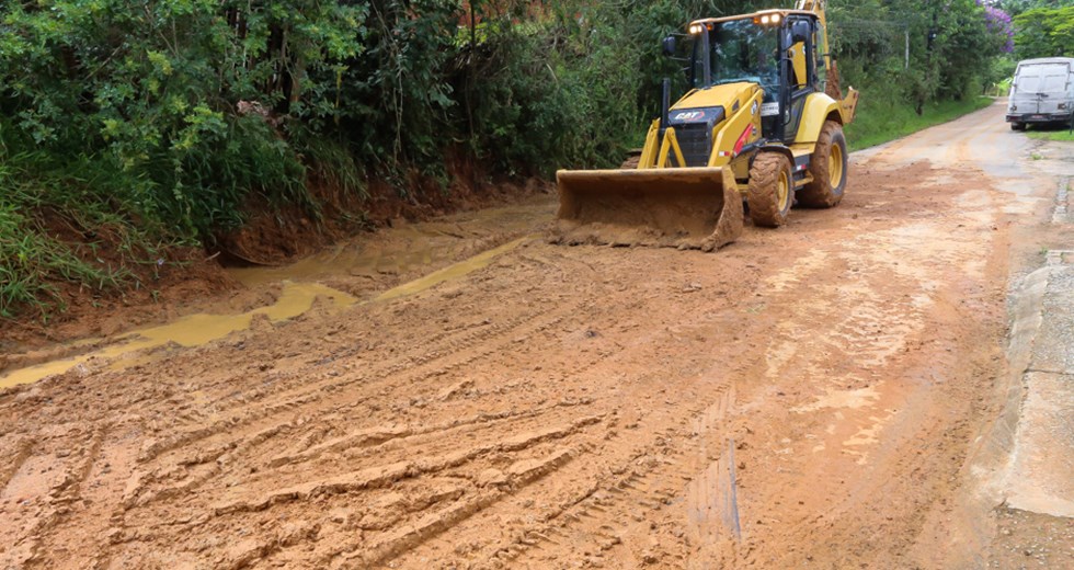 Defesa Civil trabalha nas áreas afetadas pelas chuvas em São José dos Campos com tratores; foto mostra barro e árvores.