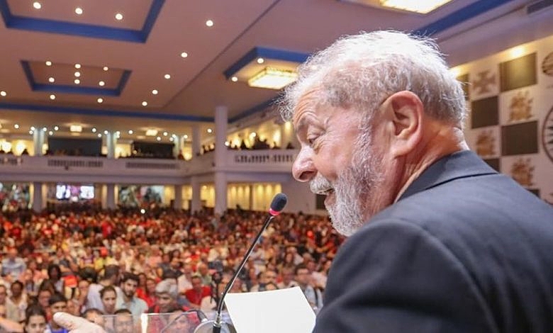 Foto mostra Lula com um terno preto, falando no microfone, em uma igreja evangélica, ilustrando matéria sobre dados divulgados pela Pesquisa Ipec.