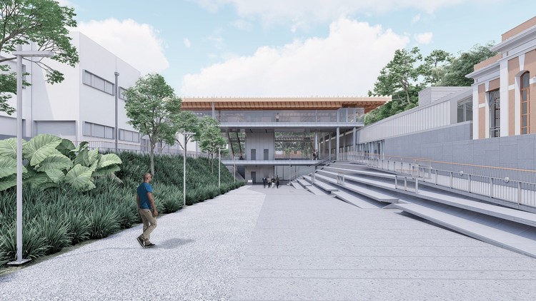 Fachada da Pinacoteca Contemporânea de São Paulo, novo museu, com céu azul, nuvens, escadas no lado direito, grama no lado esquerdo e uma pessoa andando no meio.