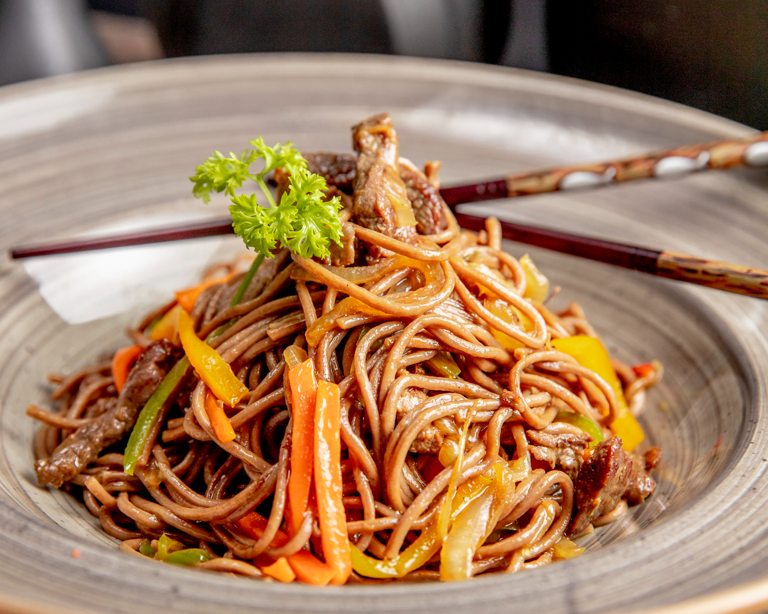 Prato de yakisoba com temperos em cima de uma mesa, ilustrando a matéria sobre o Vale Nihon SJC, evento de cultura japonesa no Vale do Paraíba.