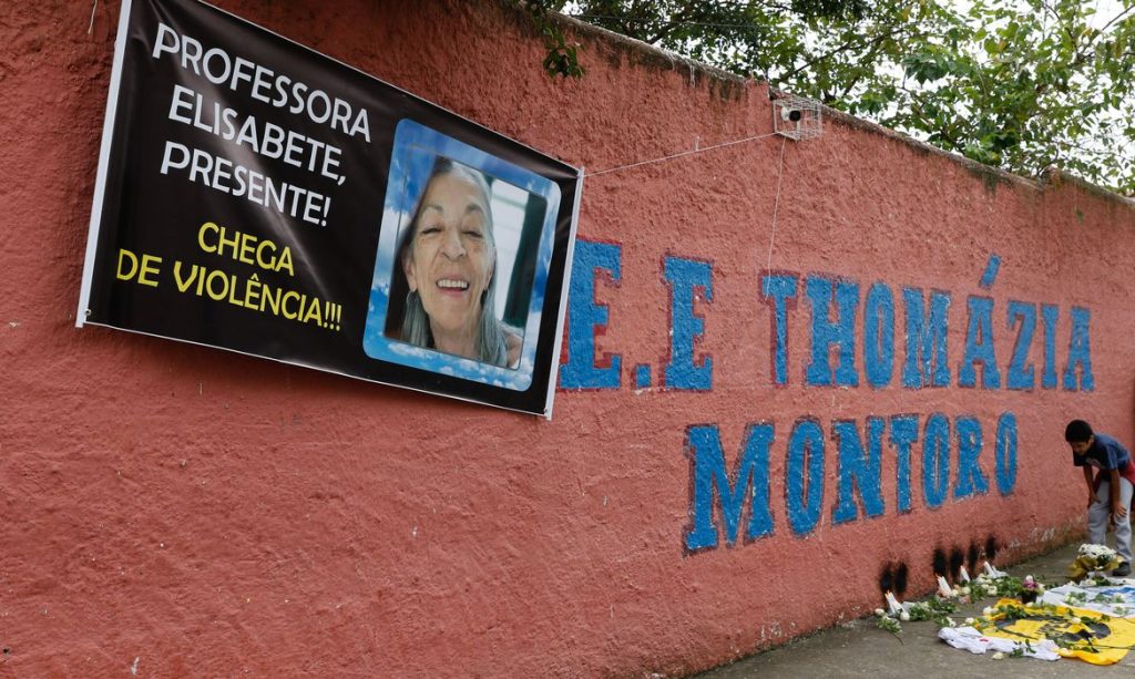 imagem de muro da escola com homenagem à professora; foto ilustra matéria sobre Estação do metrô de SP recebe nome de professora assassinada em ataque