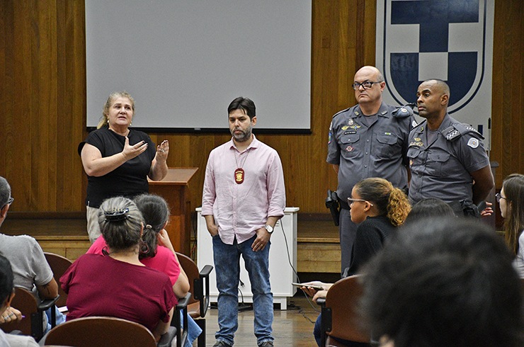Reitora da Unitau, Nara Fortes, ao lado de policiais militares durante treinamento de segurança e identificação de ameaças.