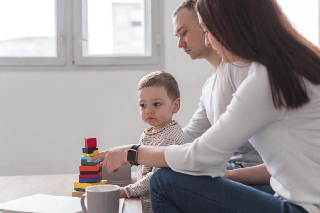 criança brincando com os pais; foto ilustra matéria sobre Vacinas causam autismo Entenda a história por trás deste mito
