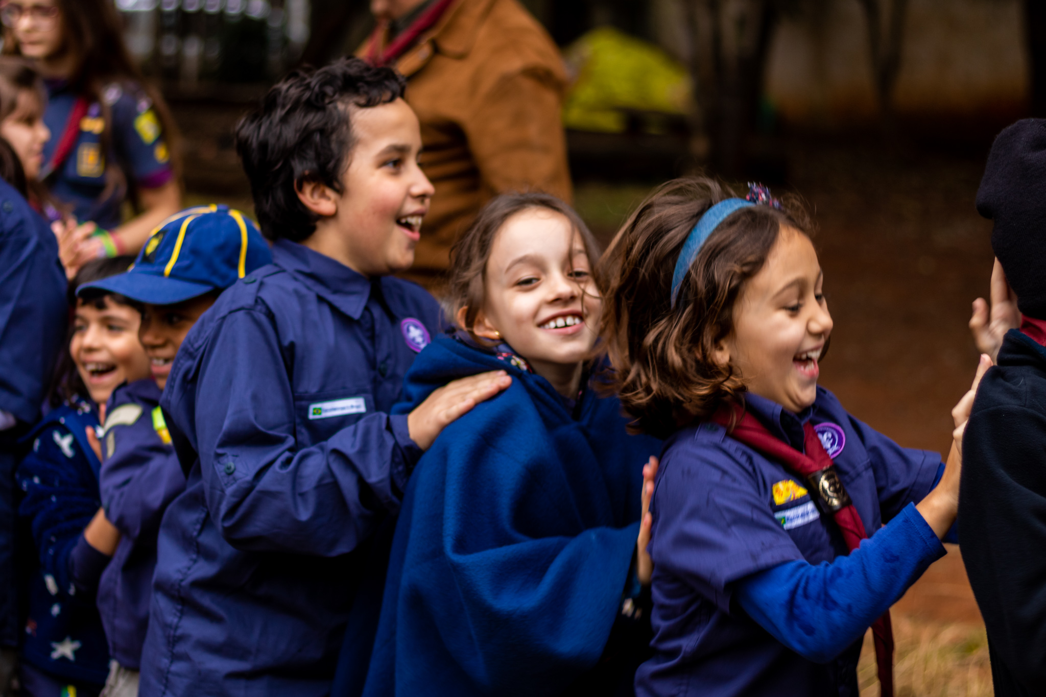 Foto ilustra matéria sobre ação dos escoteiros de São José dos Campos no Shopping Jardim Oriente; na imagem crianças usam roupas nas cores azul e amarela enquanto brincam, enfileiradas e sorrindo.