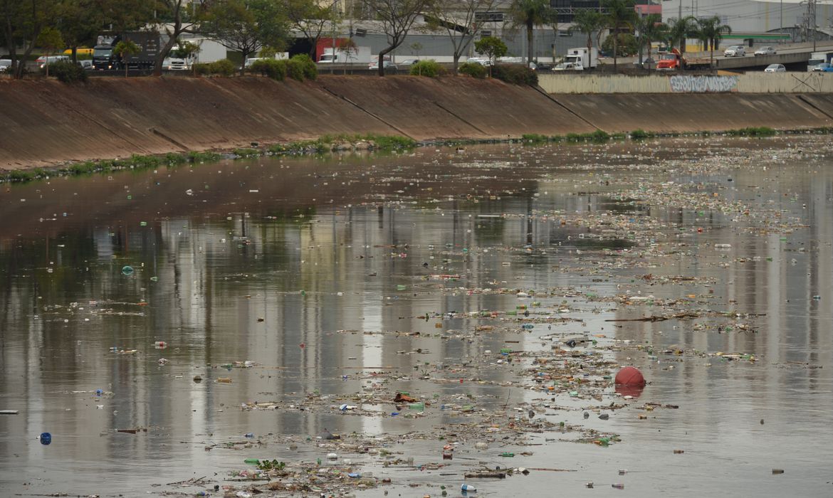 trecho do rio tietê com diversos resíduos, lixo e dejetos espalhados e acumulados na água