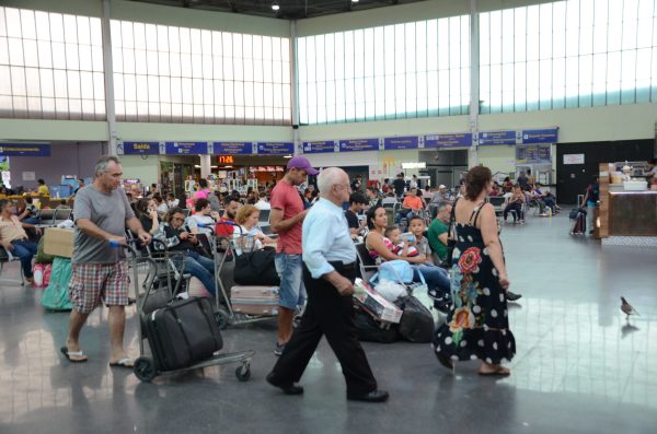terminal rodoviário intermunicipal de são josé dos campos em dia de grande movimento; imagem mostra passageiros com passagens e malas nas mãos e sentados em cadeiras; rodoviária recebe ônibus intermunicipais de todo o Brasil