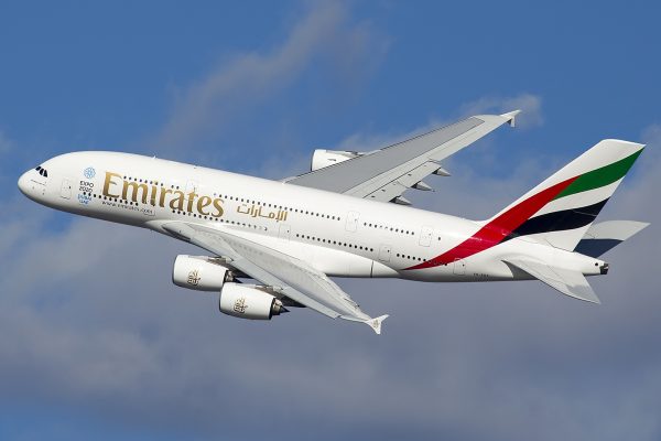 Avião branco da Emirates, voando, em direção à esquerda.