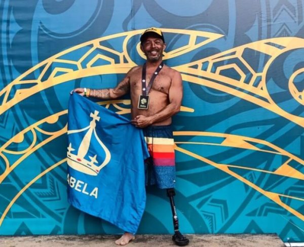 Paratleta Telmo Rodrigues, de 47 anos, segura bandeira de Ilhabela