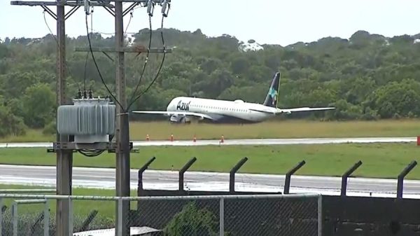 Avião da Azul sai da pista em Salvador; foto mostra o veículo branco sob um gramado verde.