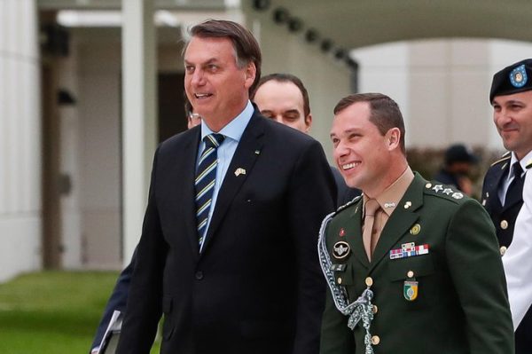 Ex-presidente Jair Bolsonaro, de terno, caminhando ao lado do tenente-coronel do exército, Mauro Cid