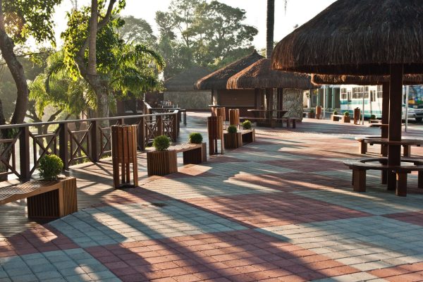 Centro de Guararema, com quiosques ao redor, árvores ao fundo e plantas.