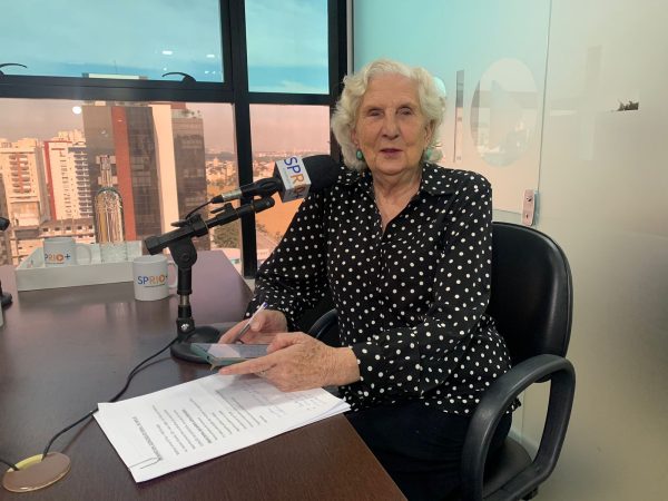 Vereadora Dulce Rita, de São José dos Campos, durante entrevista ao Portal SP RIO+, vestindo uma camisa preta, com bolinhas brancas, enquanto sorri e olha para a câmera.