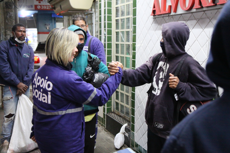 Agente de São José e cidadão apertando a mão. São José tem mais vagas nos abrigos para pessoas em situação de rua