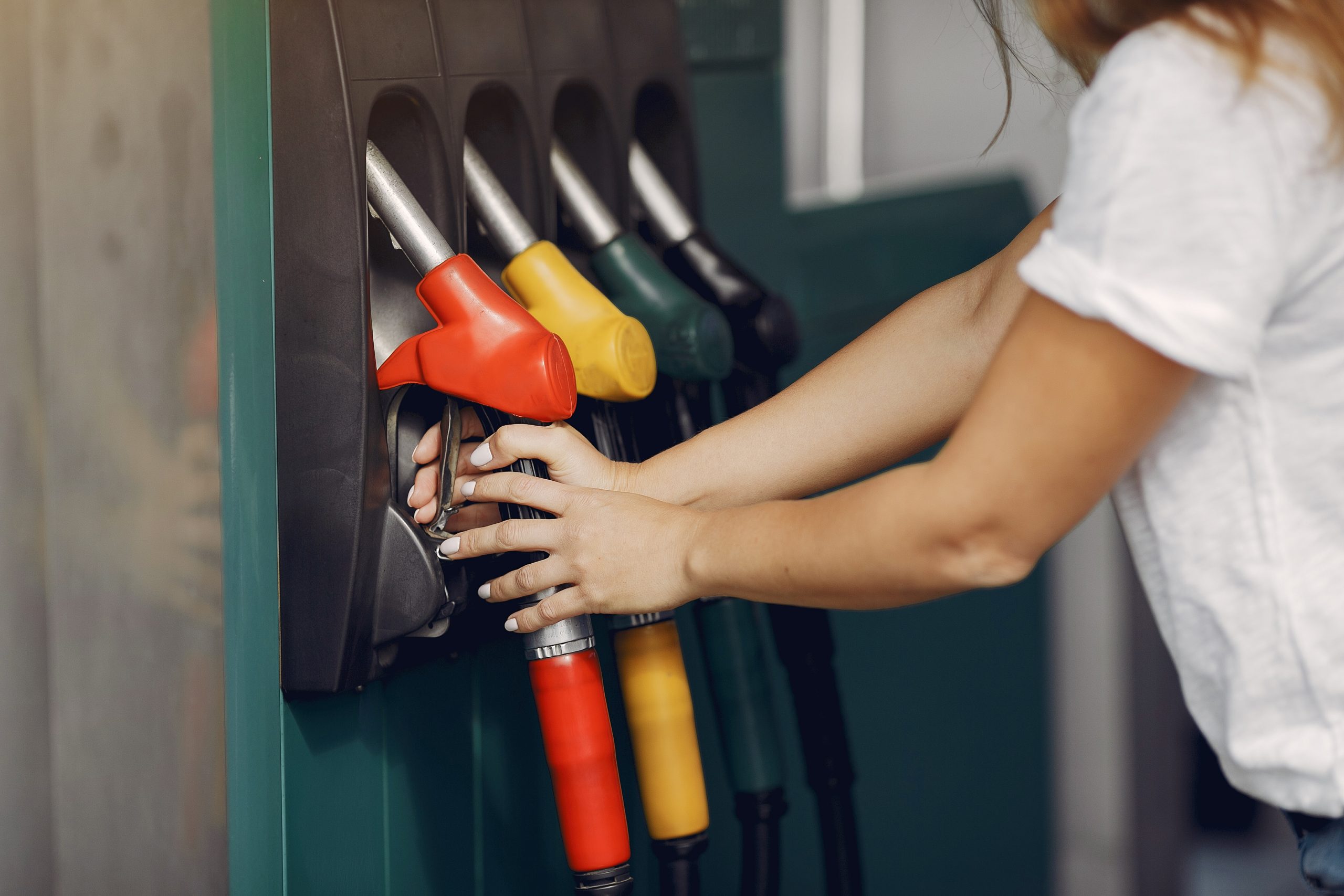 mulher em posto de gasolina. gasolina deve subir após mudança no icms