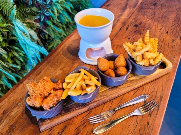 Fondue de queijo com aperitivos de batata frita, coxinha, e stik de frango