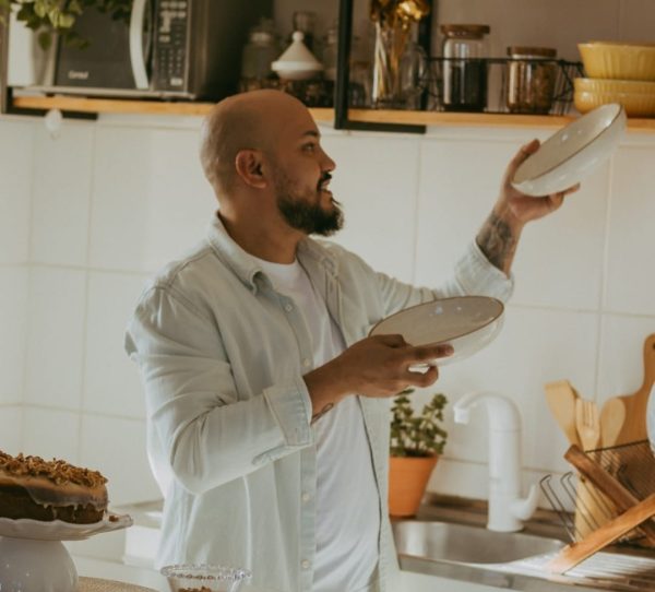 Fábio Cunha arrumando os pratos no armário.