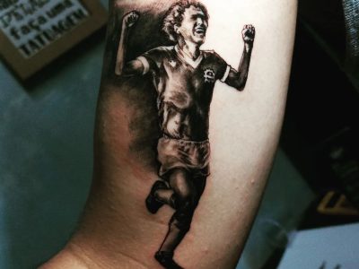 tatuagem de tião marino feita por malu em macedo. no desenho, ex-jogador veste o uniforme do são josé e comemora um de seus gols pelo clube.