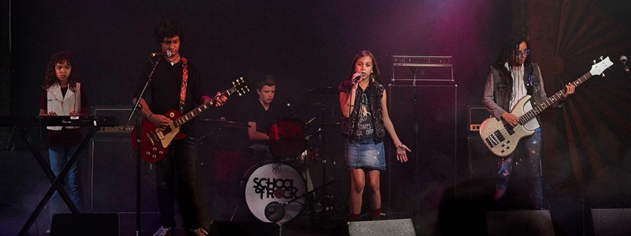 Alunos da escola de música School Of Rock durante apresentação com banda