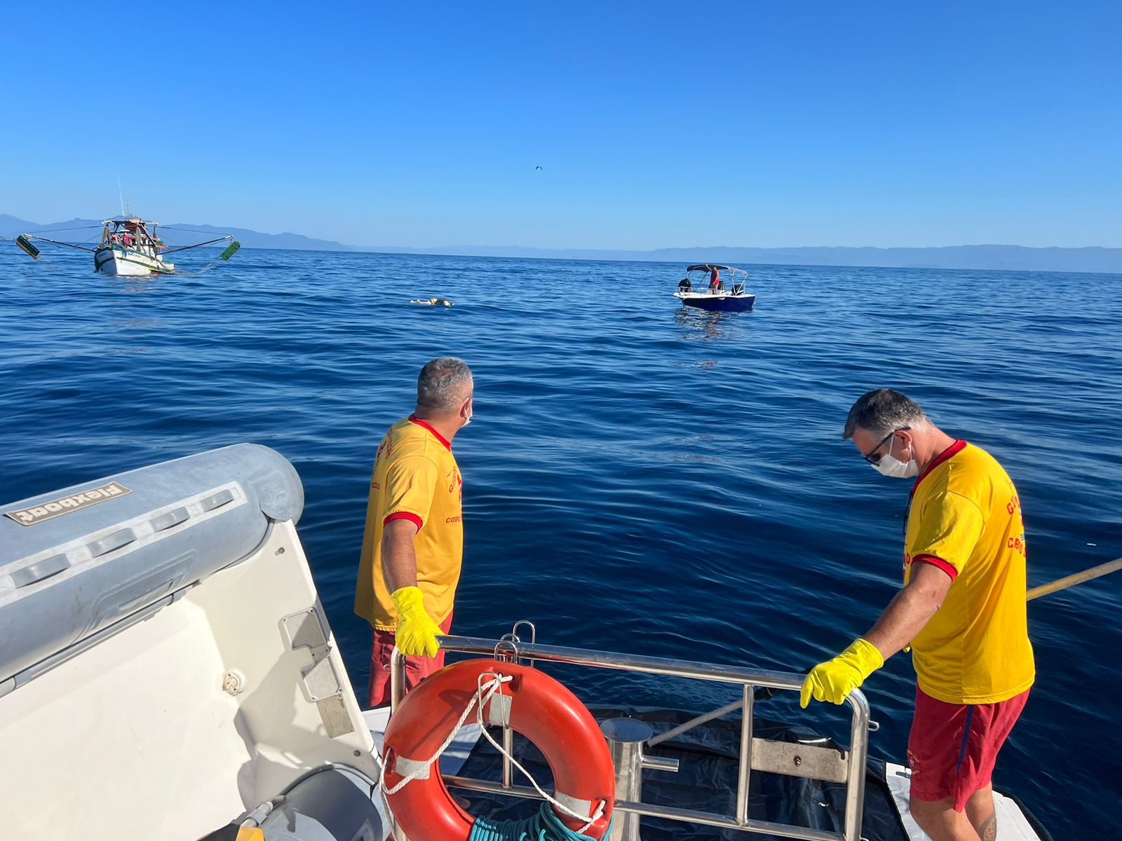 Dois bombeiros em uma lancha em alto mar na região da Ilha Vitória em Ubatuba