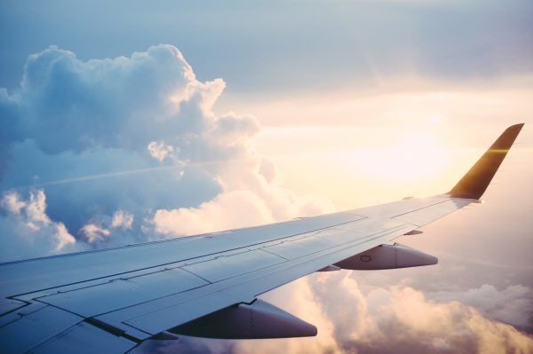 vista de janela de avião durante voo no final da tarde com sol se pondo; brasil deve ter passagens a R$ 200 em agosto