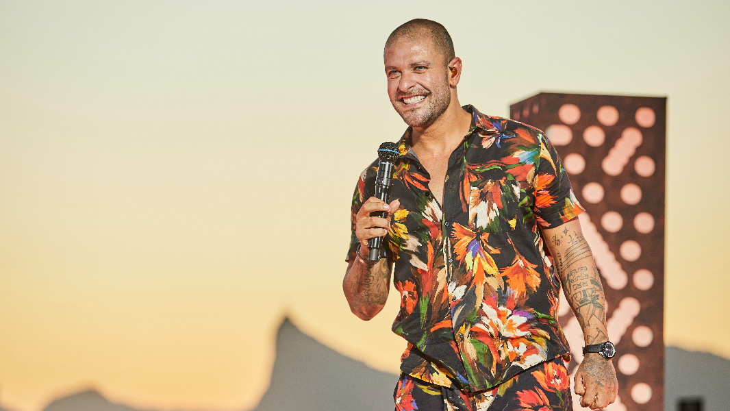 Cantor e sambista Diogo Nogueira com microfone na mão durante show