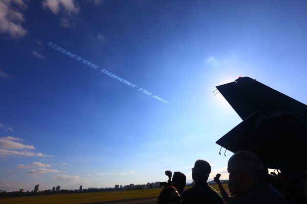 "santos dumont 150 anos" escrito no céu em fumaça feita pelos aviões da esquadrilha