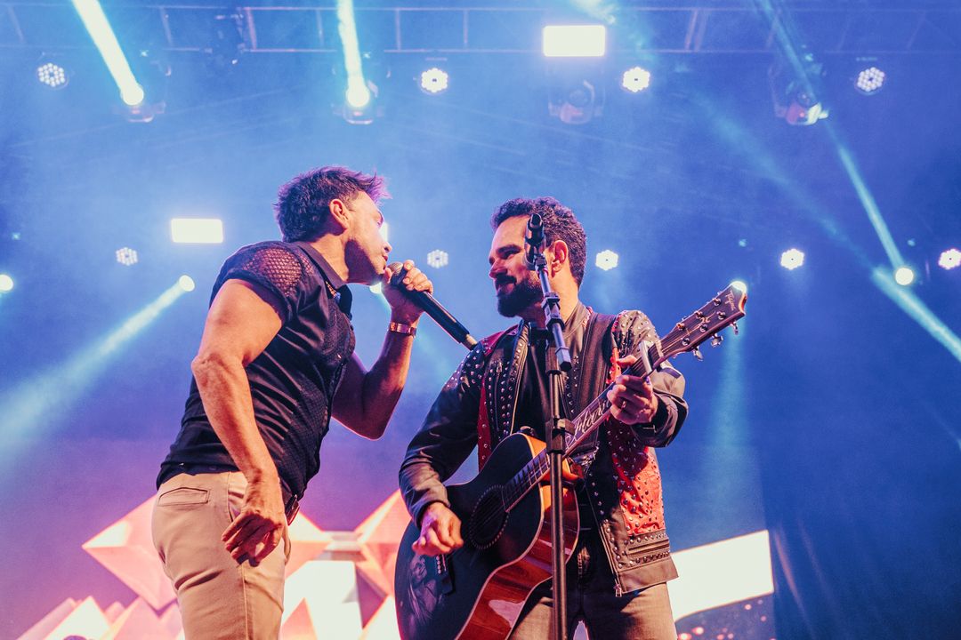 zezé di camargo e luciano, que vão se apresentar em sjc, cantando e olhando um para o outro