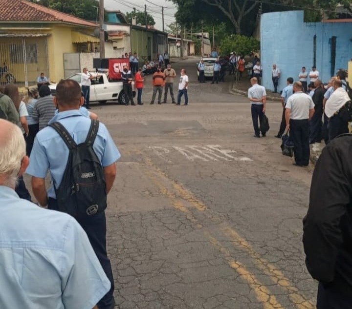 Trabalhadores reunidos em frente a a garagem de ônibus durante paralisação em SJC
