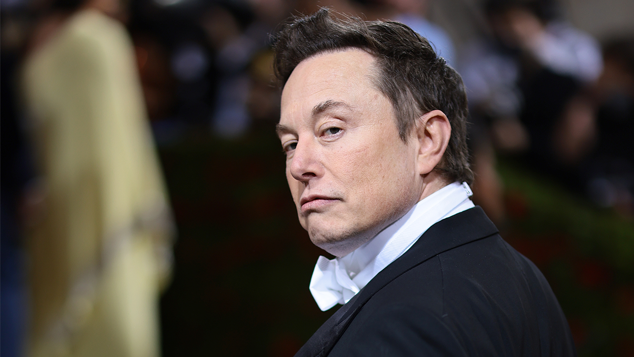 elon musk, proprietário do twitter, de perfil e com cara de desconfiança
