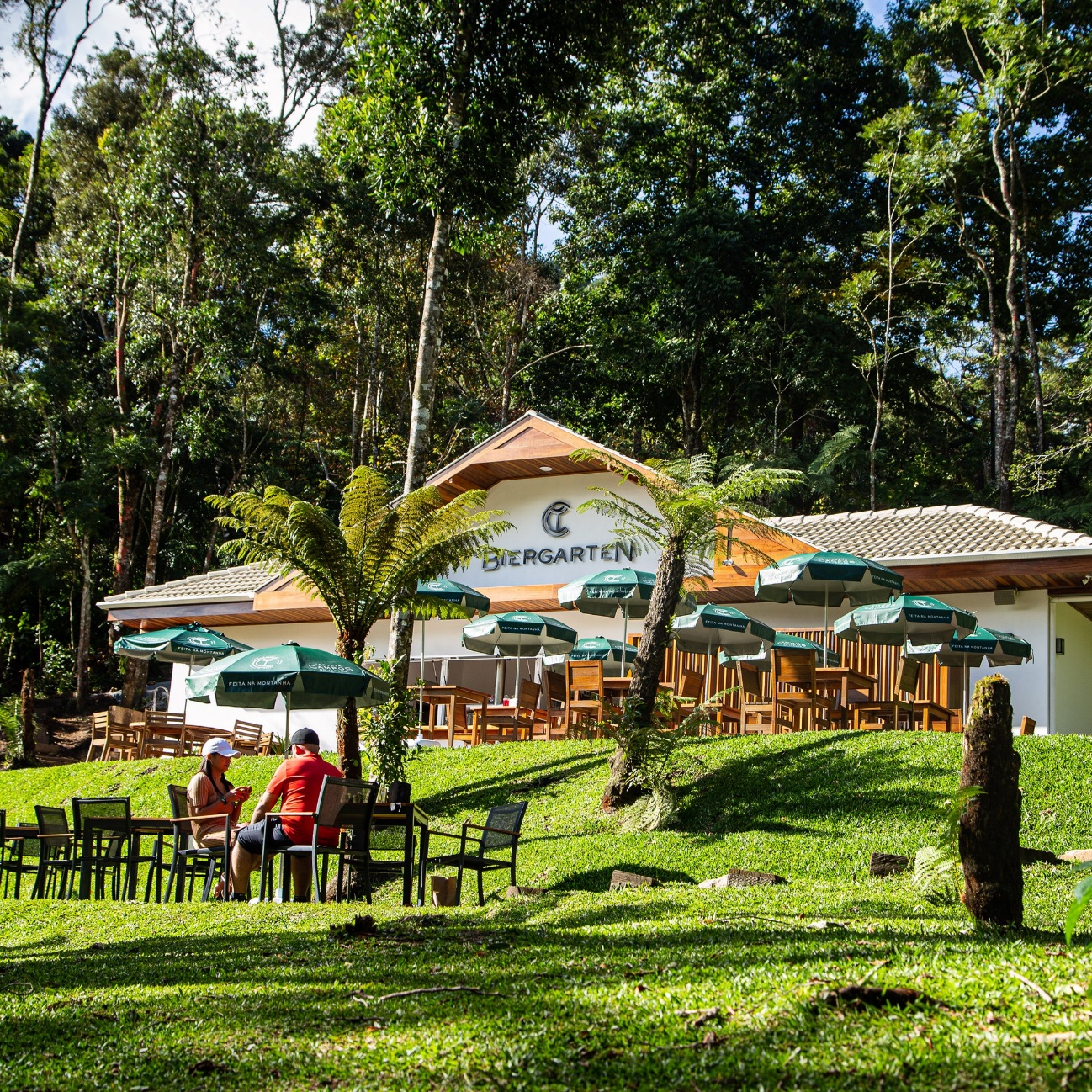 Parque da Cerveja em Campos do Jordão, com árvores, mesas e cadeiras ao ar livre