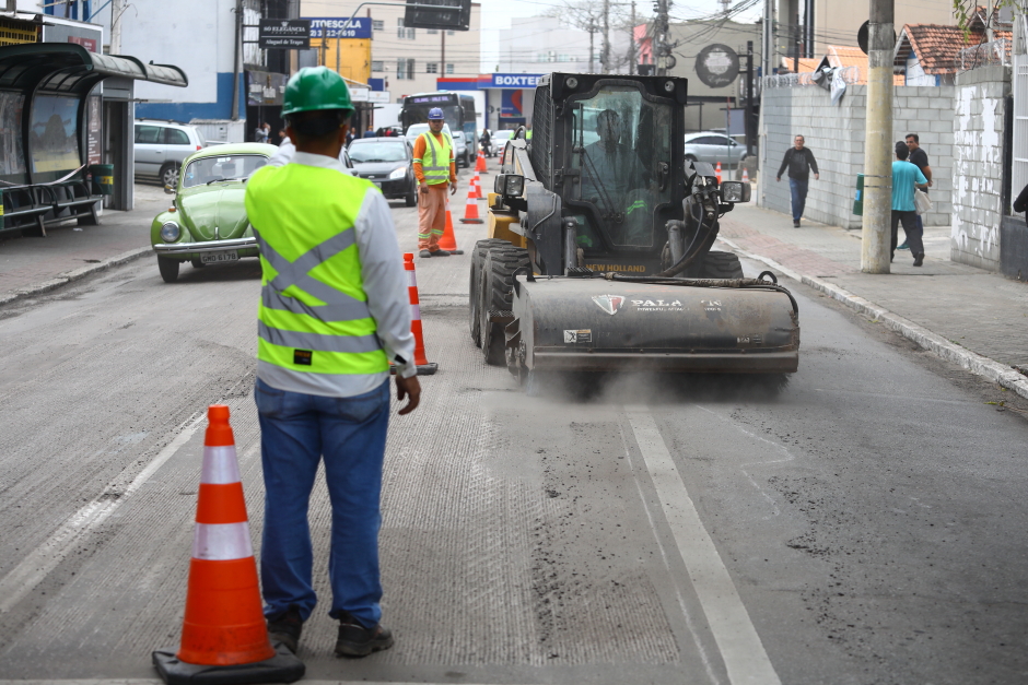 agente de obras ao lado de cone na rua francisco paes, no centro de sjc, observando movimentação de trator