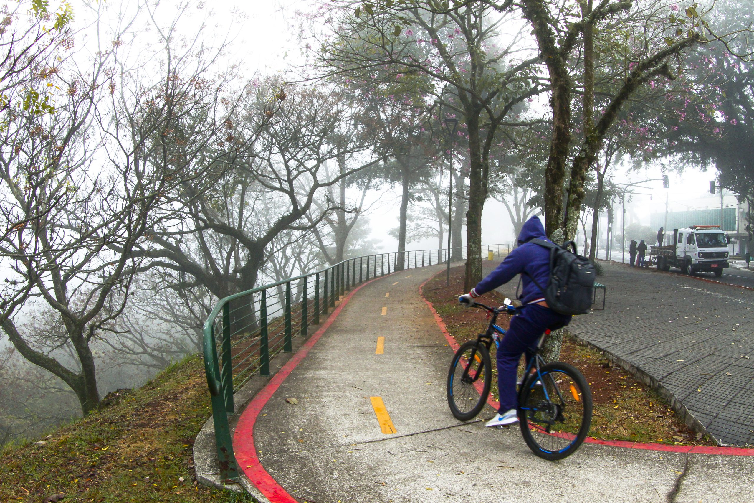 Homem de bicicleta durante frio e chuva em São José