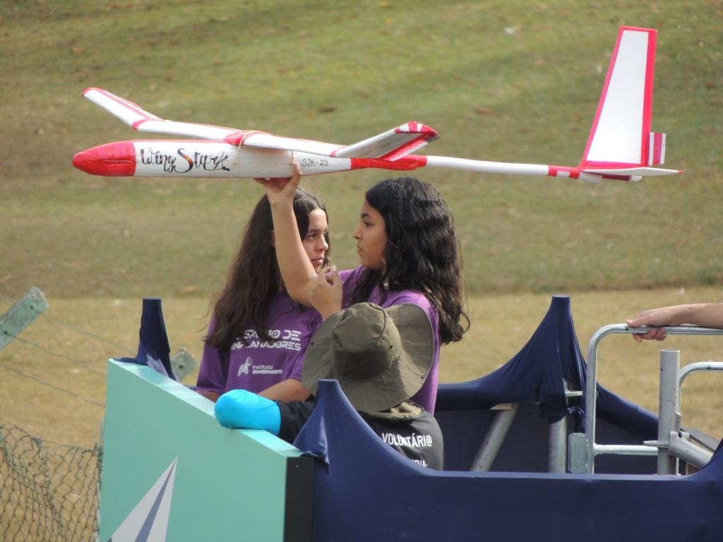 Menina segurando seu avião durante campeonato de miniplanadores da Embraer