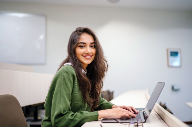 Mulher em computador; Embraer oferece capacitação para mulheres em tecnologia
