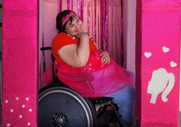frequentadora do centro da juventude tirando foto na caixa da barbie inclusiva