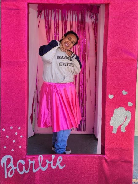 frequentadora do centro da juventude tirando foto na caixa da barbie inclusiva