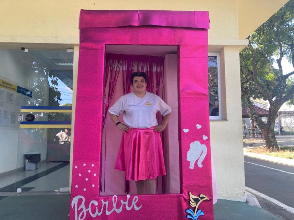 frequentadora do centro da juventude tirando foto na caixa da barbie inclusiva