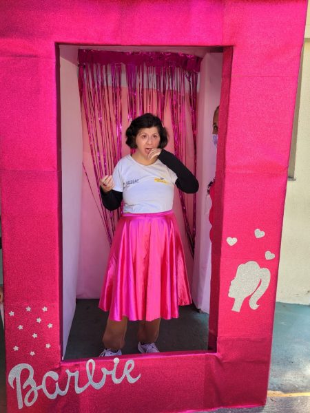 frequentadora do centro da juventude tirando foto na caixa da barbie inclusiva