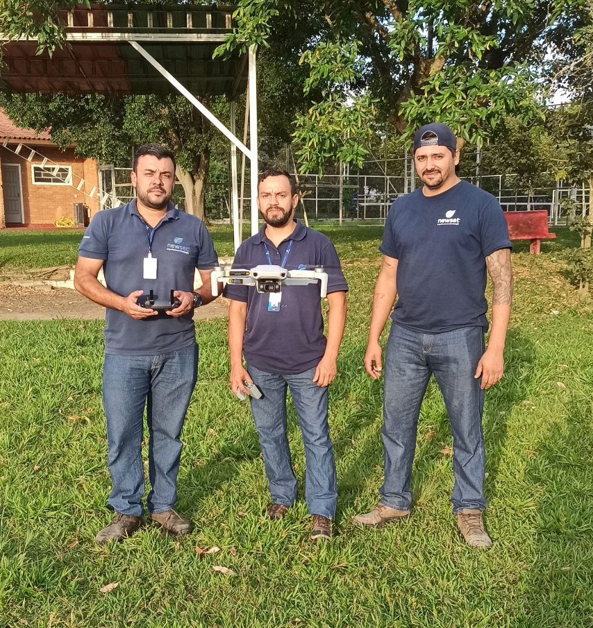 Professores de curso de drone em São José, em pé, controlando drone no ar