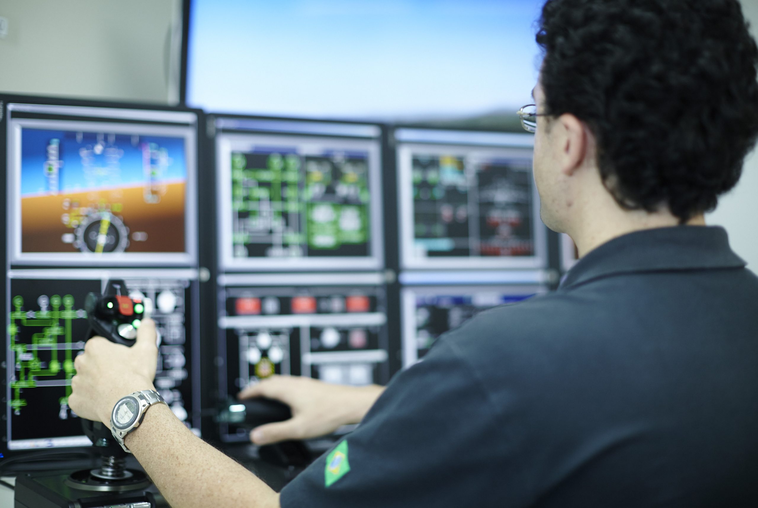 Homem mexendo em software da Embraer, que está com inscrições abertas para programa de bolsas de estudo de pós graduação