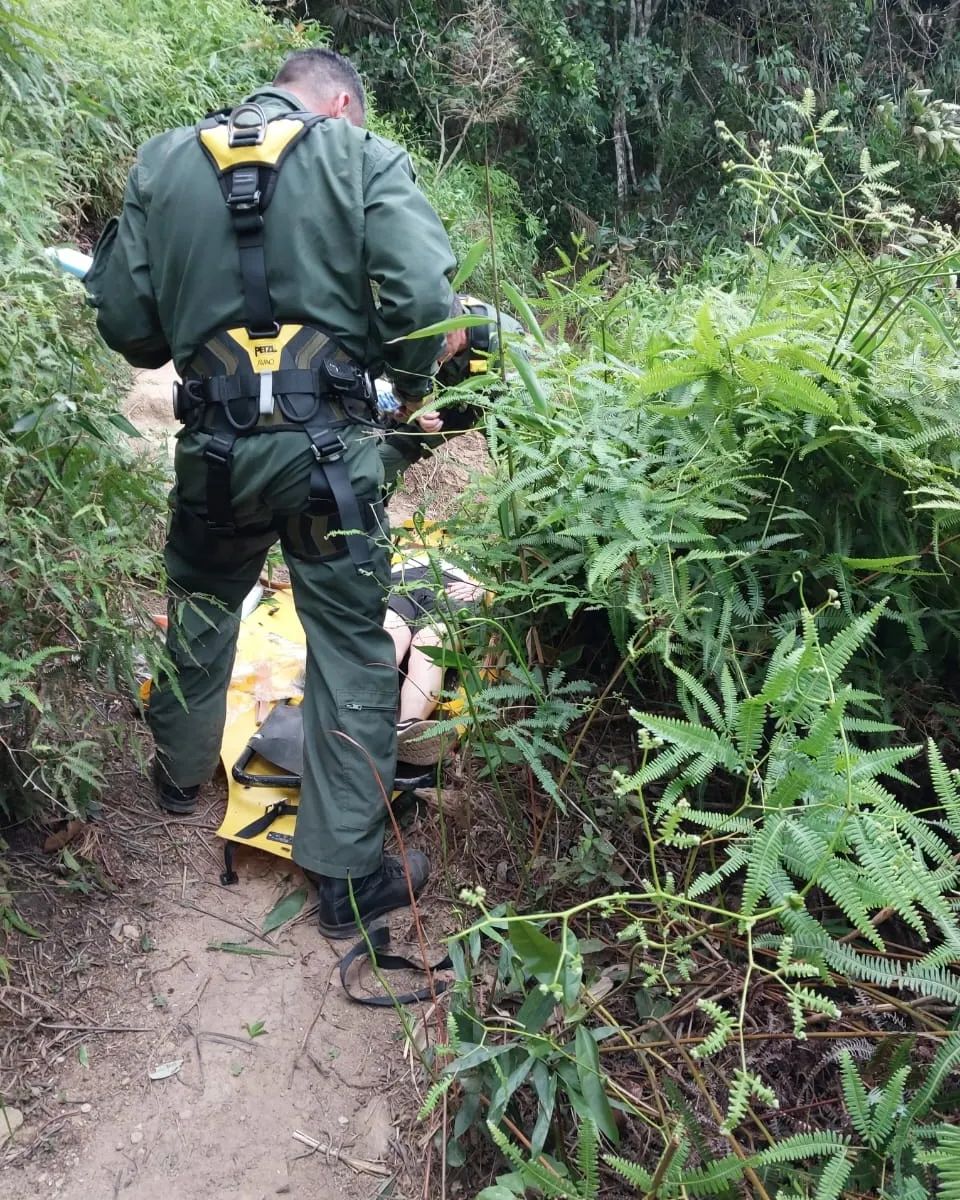 Mulher durante resgate pelo Águia na trilha das Sete Praias em Ubatuba