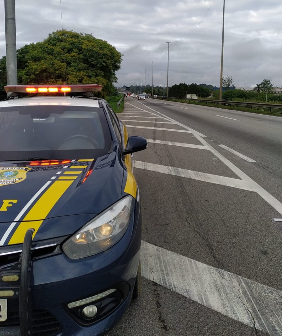 Viatura da PRF estacionada na via Dutra para orientar peregrinos após romeiro ser atropelado em Guararema