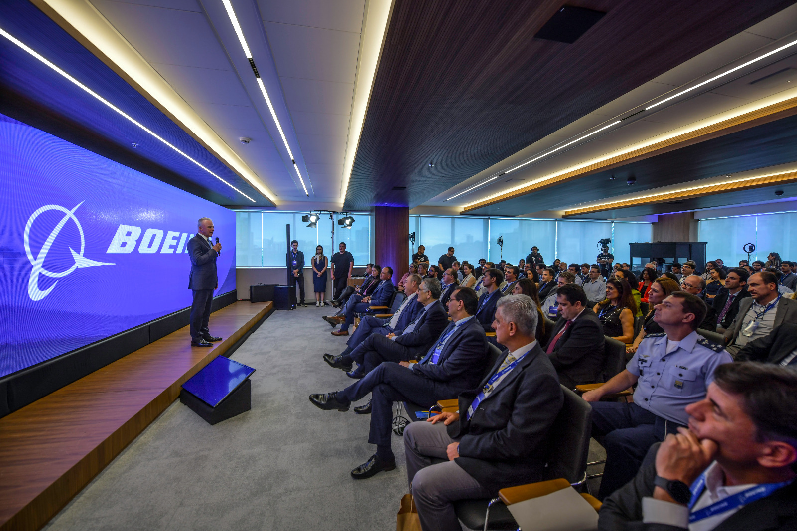 brandon nelson discursando em auditório para autoridades, imprensas e funcionários da boeing