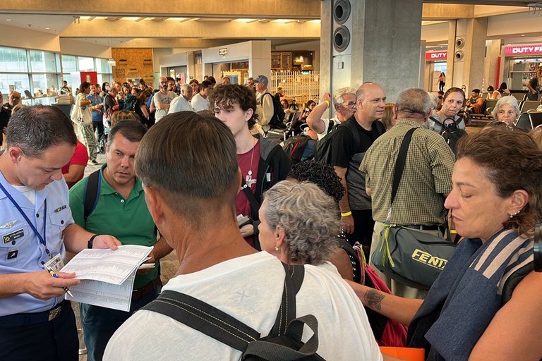 brasileiros em aeroporto aguardando retorno de israel ao brasil