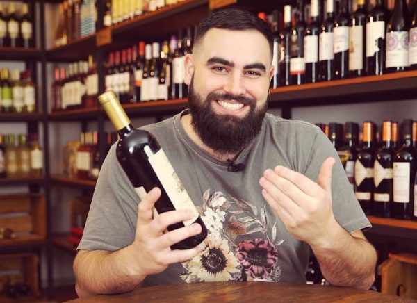 rodrigo ferraz sorrindo e segurando garrafa de vinho; ele será uma das atrações entre chefs e sommelier no jantar em são josé