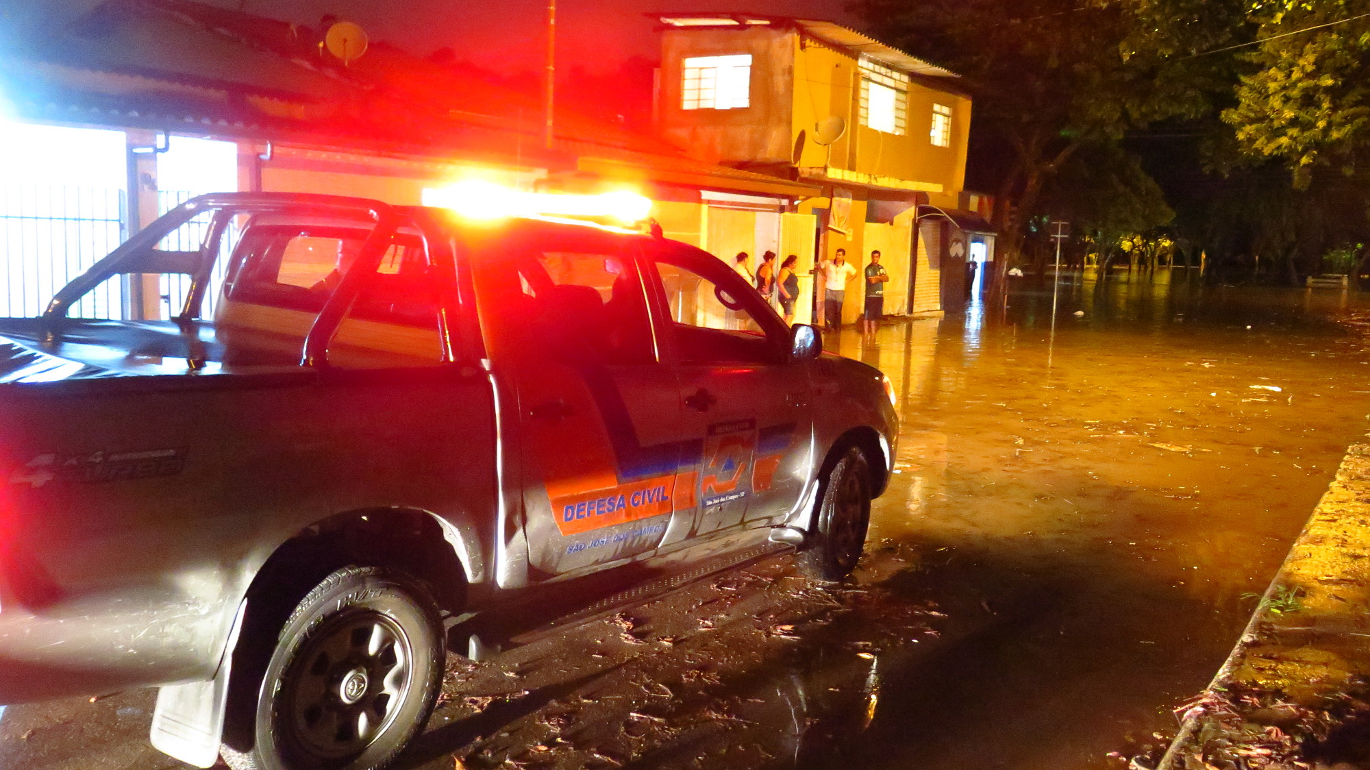 viatura da defesa civil em área alagada em são josé dos campos durante a noite