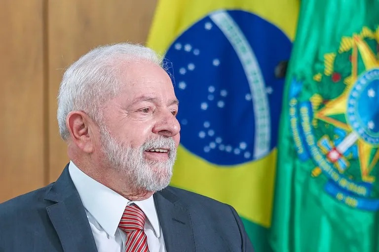 Presidente Lula de terno em frente a bandeira do Brasil; em pronunciamento de Natal ele falou sobre ódio a democracia desuniu famílias