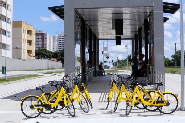 duas filas com três bicicletas cada lado a lado estacionadas na horizontal em frente à estação da linha verde