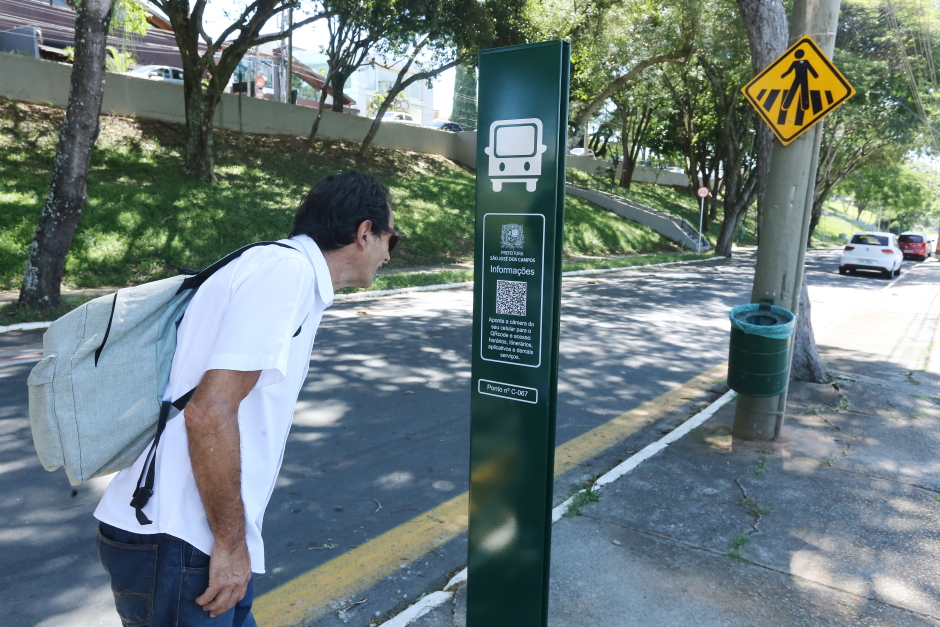 homem analisando toten em ponto de ônibus em são josé